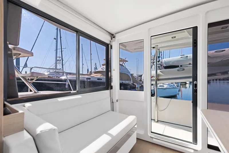Slide: The Image of Interior view of 2018 Bali 4.0 catamaran with marina backdrop through windows. - 8