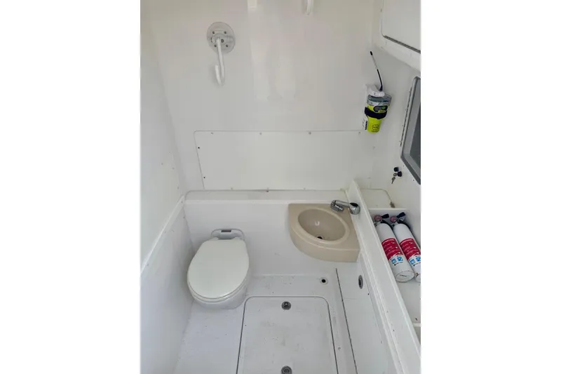 Slide: The Image of 2020 Invincible 36 Open Fisherman boat bathroom with toilet, sink, and fire extinguishers. - 11