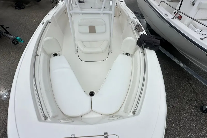 Slide: The Image of 2014 Tidewater 210 CC Adventure boat interior with white seating and storage compartments. - 10