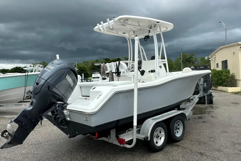 Slide: The Image of 2014 Tidewater 210 CC Adventure boat on trailer, featuring Yamaha 150 engine, under cloudy sky. - 12