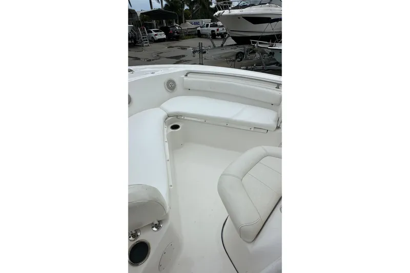 Slide: The Image of 2014 Tidewater 210 CC Adventure boat interior with white seating and cup holders. - 13