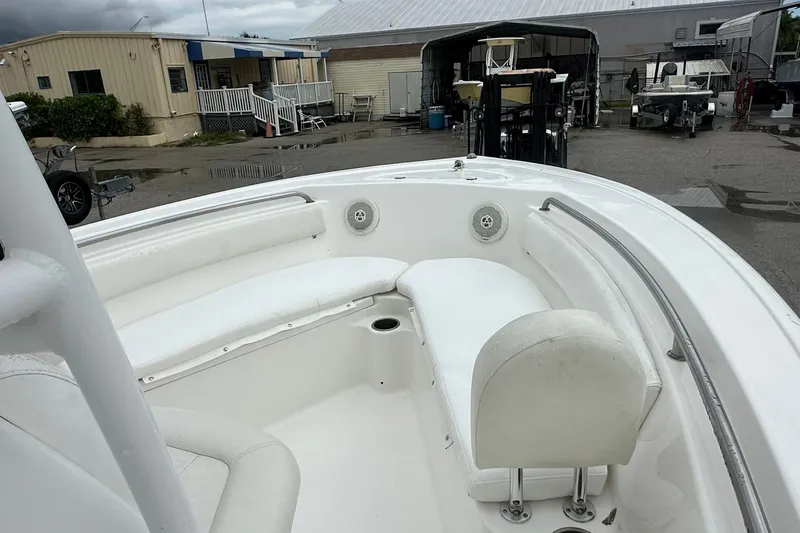 Slide: The Image of 2014 Tidewater 210 CC Adventure boat with white seating, docked at a marina. - 7