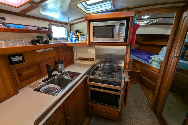 Slide: The Image of Cozy kitchen in 2000 Duffy Flybridge 37 boat with stove, sink, and microwave. - 13