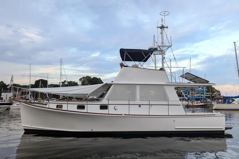 Slide: The Image of 2000 Duffy Flybridge 37 yacht docked at marina under a cloudy sky. - 26