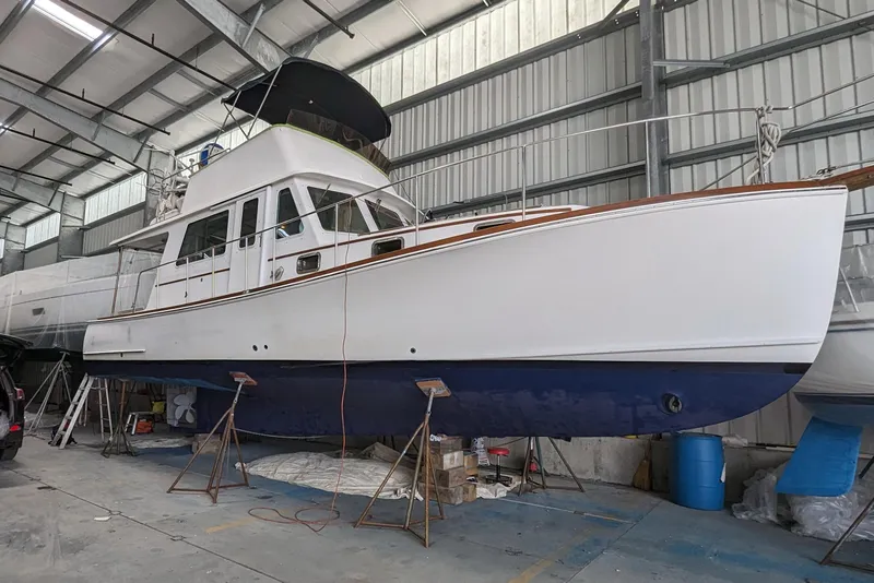 Slide: The Image of 2000 Duffy Flybridge 37 boat in a storage facility, elevated on stands. - 27