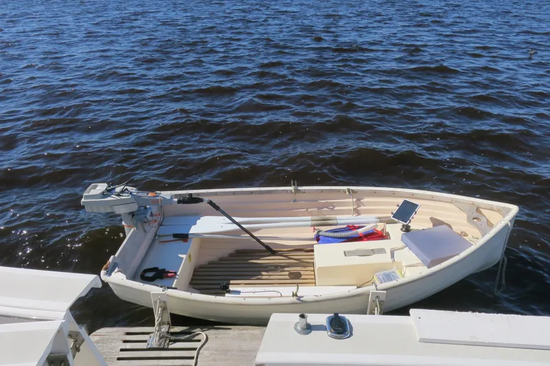 Slide: The Image of Small boat docked on water, equipped with an outboard motor and oars. - 7