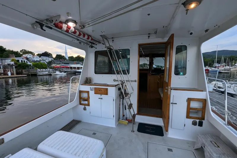 Slide: The Image of Duffy Flybridge 37 boat interior, docked at a scenic marina, showcasing spacious deck area. - 8