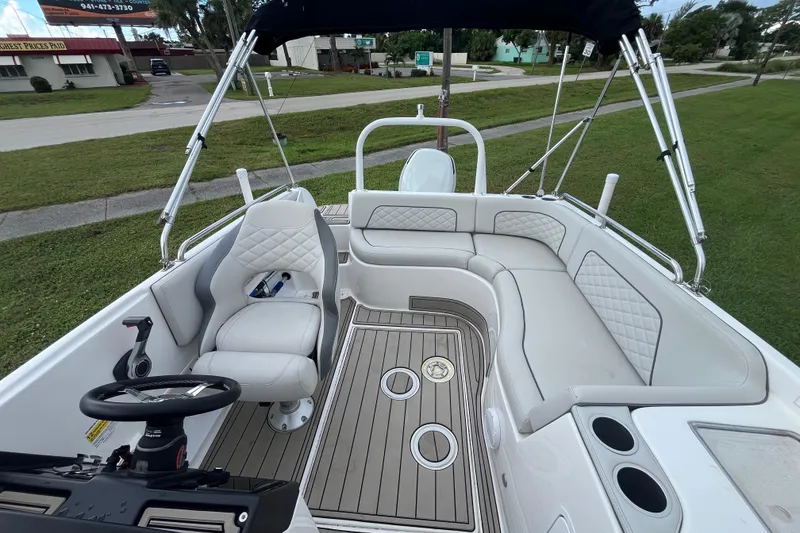 Slide: The Image of 2022 Citation 240 boat interior with white seating and steering wheel, parked on grass. - 11