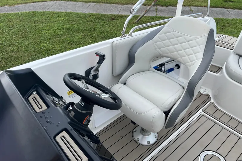 Slide: The Image of Steering area of 2022 Citation 240 boat with white cushioned seat and control panel. - 13