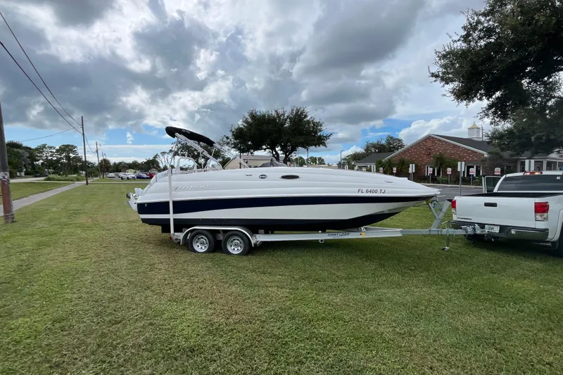Slide: The Image of 2022 Citation 240 boat on trailer, parked on grass, cloudy sky background. - 3