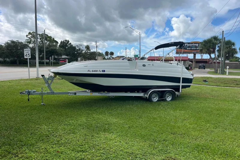 Slide: The Image of 2022 Citation 240 boat on trailer, parked on grass near road with speed limit sign. - 4
