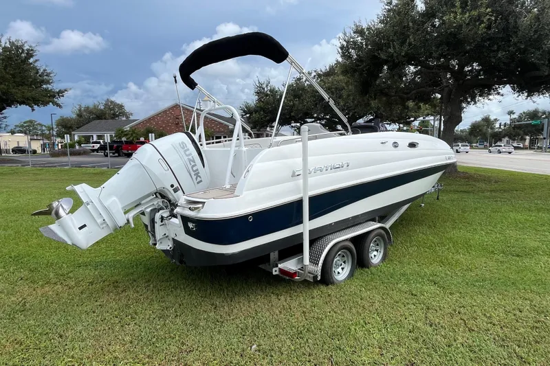 Slide: The Image of 2022 Citation 240 boat with Suzuki outboard motor on trailer, parked on grass. - 5
