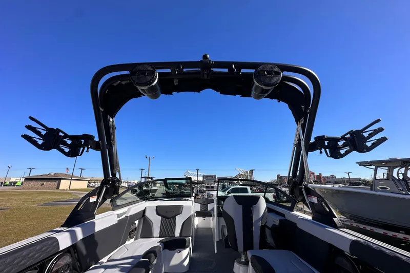 Slide: The Image of 2025 MasterCraft XT24 boat interior with wakeboard tower and speakers under clear blue sky. - 11