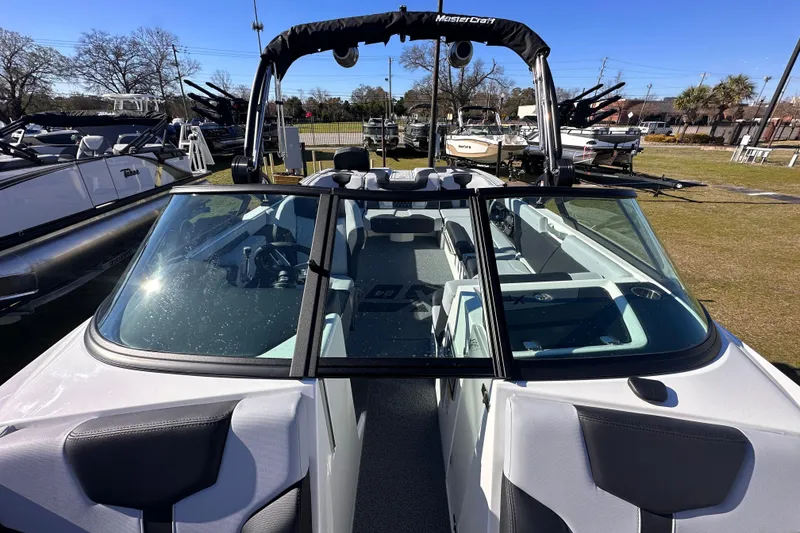 Slide: The Image of 2025 MasterCraft XT24 boat with sleek design and spacious interior, displayed outdoors. - 14