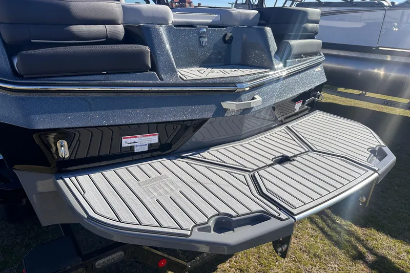 Slide: The Image of 2025 MasterCraft XT24 boat rear view with swim platform and seating. - 16