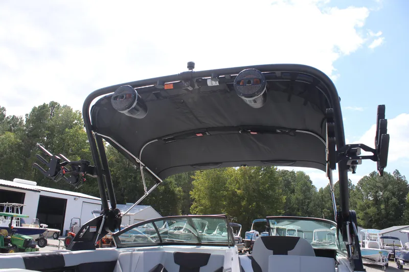 Slide: The Image of 2025 MasterCraft XT24 boat with speakers and wakeboard racks under a sunny sky. - 7