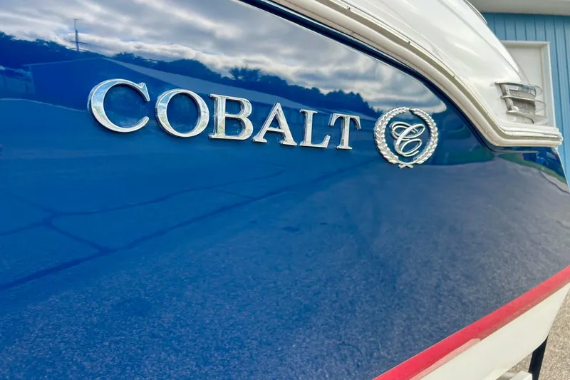Slide: The Image of 2010 Cobalt 276 boat with logo on blue hull, reflecting sky and surroundings. - 17