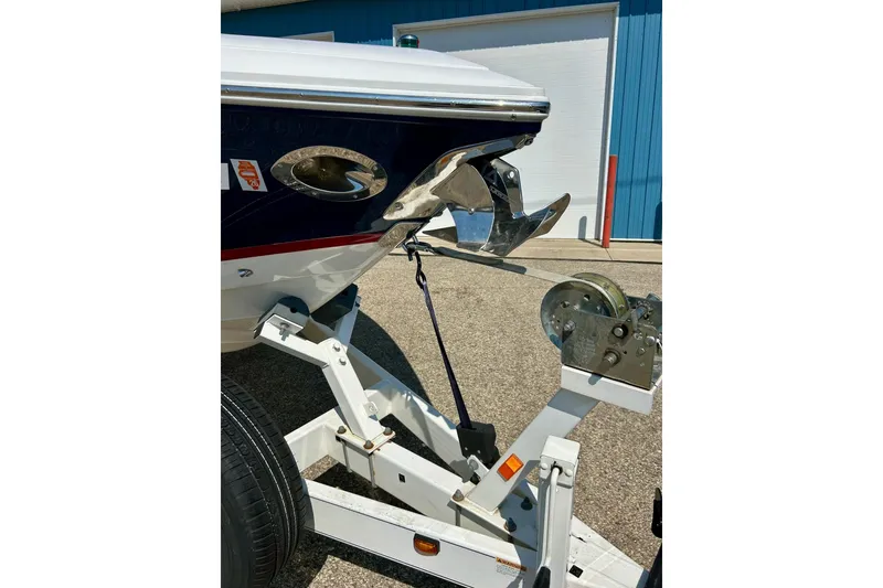 Slide: The Image of 2010 Cobalt 276 boat on trailer, featuring a shiny anchor and blue hull. - 36