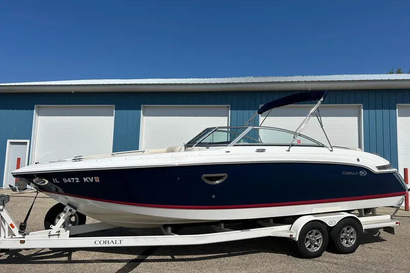 Slide: The Image of 2010 Cobalt 276 boat on trailer, parked outside blue building. - 37