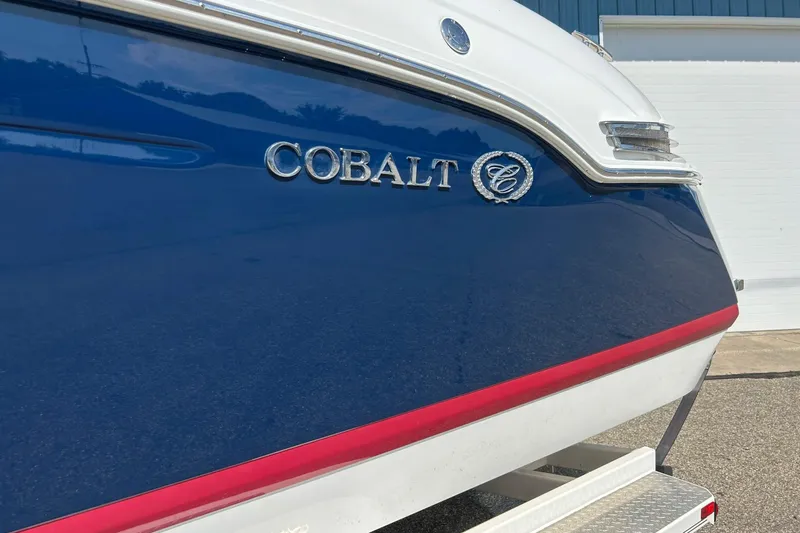 Slide: The Image of 2010 Cobalt 276 boat with blue and white exterior, docked outdoors. - 39