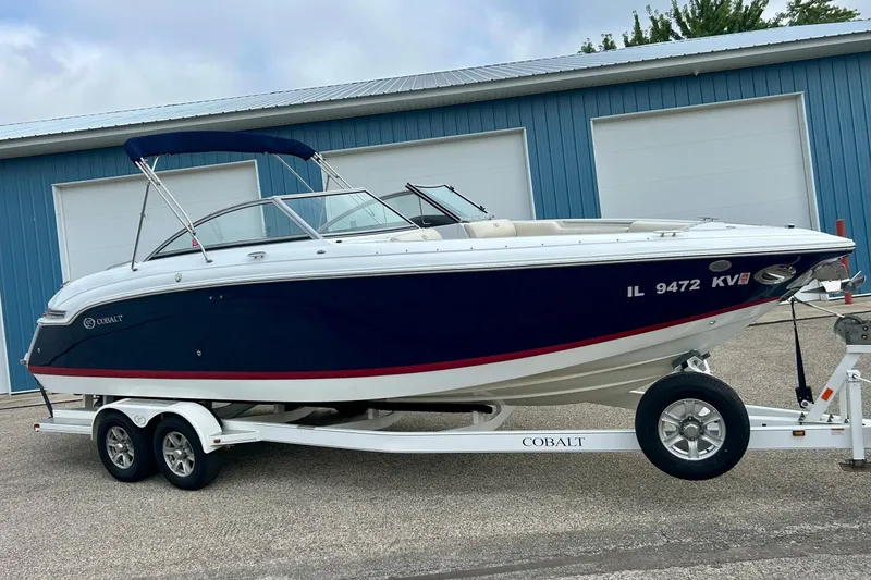 Slide: The Image of 2010 Cobalt 276 boat on trailer, parked near blue garage doors. - 4