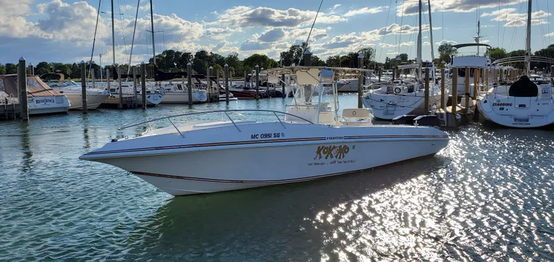 The Image of 1996 Fountain 31 Tournament Edition boat docked in a marina under a partly cloudy sky. - 0