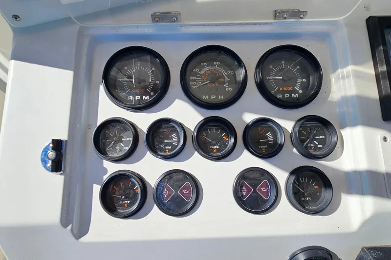 Slide: The Image of 1996 Fountain 31 Tournament Edition boat cockpit with steering controls and cushioned seating. - 21