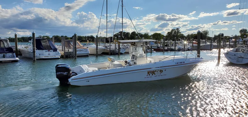 Slide: The Image of 1996 Fountain 31 Tournament Edition boat docked in a marina, reflecting sunlight on water. - 3