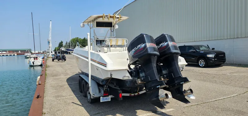 Slide: The Image of 1996 Fountain 31 Tournament Edition boat with fishing rod holders, parked in a sunny lot. - 34
