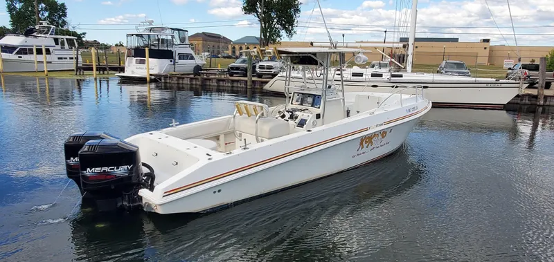 Slide: The Image of 1996 Fountain 31 Tournament Edition boat on trailer in parking lot, clear blue sky. - 7