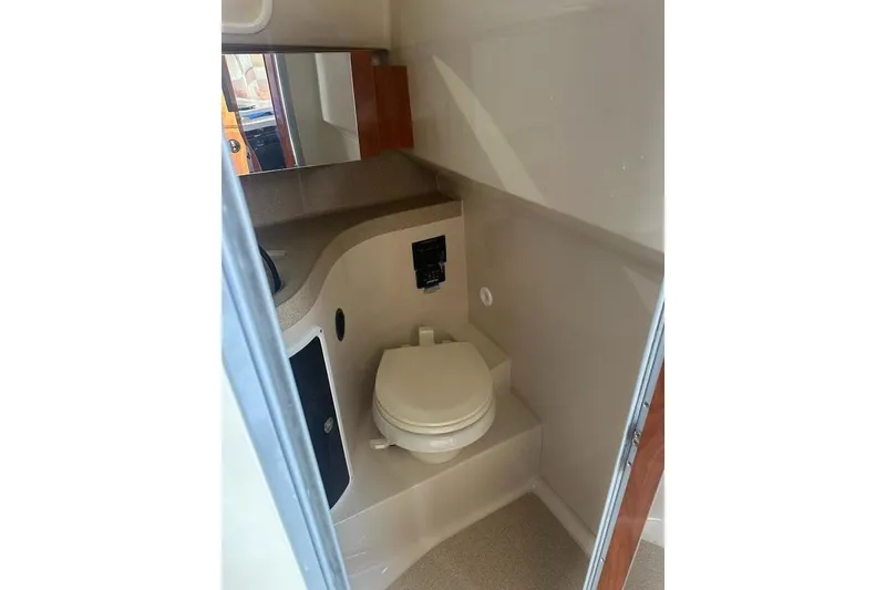 Slide: The Image of Interior of 2010 Wellcraft 290 Coastal Walk-Around boat bathroom with toilet and mirror. - 13