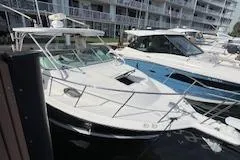 Slide: The Image of 2010 Wellcraft 290 Coastal Walk-Around boat docked near waterfront buildings. - 2