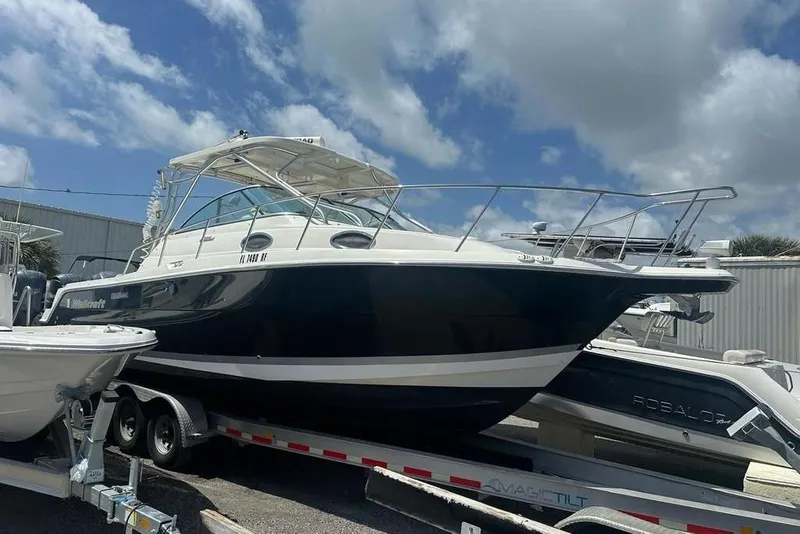 Slide: The Image of 2010 Wellcraft 290 Coastal Walk-Around boat on trailer under blue sky. - 3