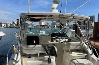 Slide: The Image of 2010 Wellcraft 290 Coastal Walk-Around boat docked in a marina with city skyline. - 5