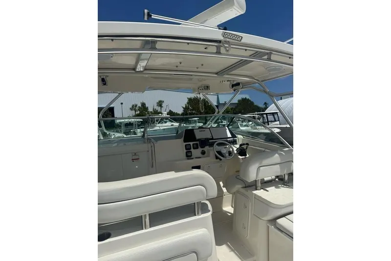 Slide: The Image of 2010 Wellcraft 290 Coastal Walk-Around boat interior with helm and seating. - 7