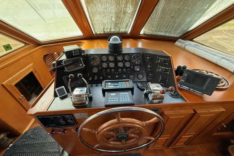 Slide: The Image of 1989 Jefferson Marquessa 52 yacht helm with navigation instruments and wooden steering wheel. - 10