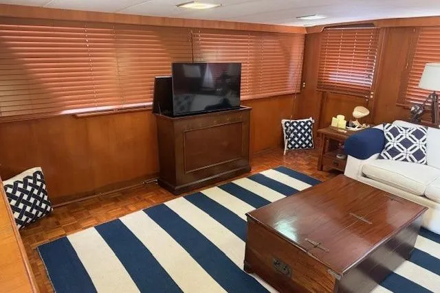 Slide: The Image of Luxurious 1989 Jefferson Marquessa 52 yacht interior with TV, striped rug, and elegant wood paneling. - 14