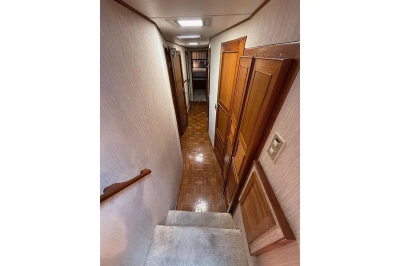 Slide: The Image of Interior hallway of 1989 Jefferson Marquessa 52 yacht with wooden doors and carpeted stairs. - 20