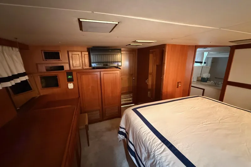 Slide: The Image of Interior of 1989 Jefferson Marquessa 52 yacht with wood paneling and cozy bedroom. - 25