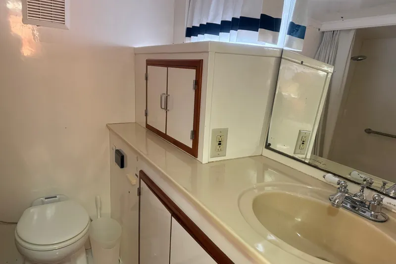 Slide: The Image of Bathroom interior of 1989 Jefferson Marquessa 52 yacht with sink, mirror, and storage cabinets. - 26