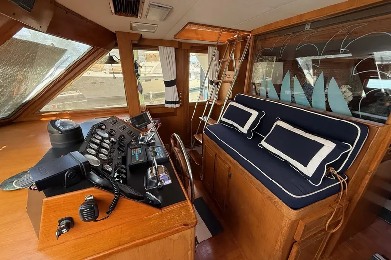 Slide: The Image of Interior of 1989 Jefferson Marquessa 52 yacht with helm and cushioned seating. - 9