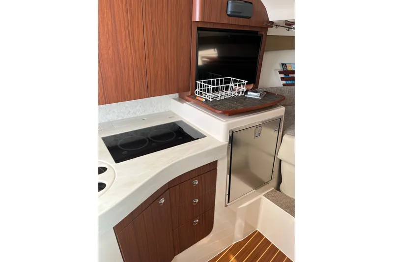 Slide: The Image of 2020 Grady-White Express 330 interior with kitchenette, stove, and storage cabinets. - 18