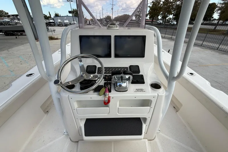 Slide: The Image of 2021 Blue Wave 2800 Makaira boat console with steering wheel and dual screens. - 16