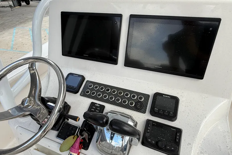 Slide: The Image of 2021 Blue Wave 2800 Makaira boat dashboard with dual Garmin displays and controls. - 17