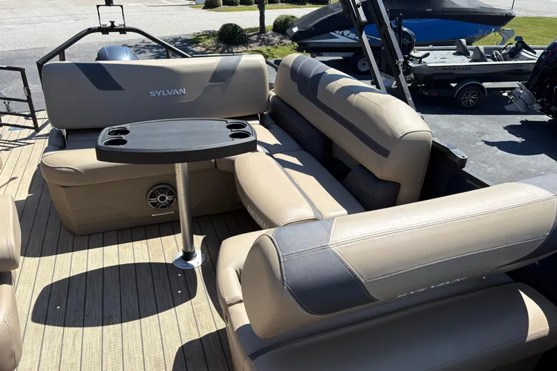 Slide: The Image of 2024 Sylvan L3 CLZ pontoon boat interior with beige seating and a central table. - 15