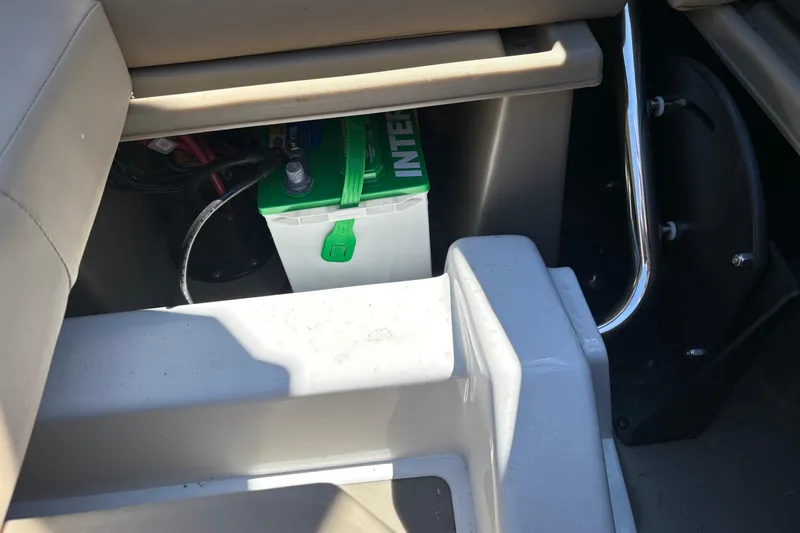 Slide: The Image of Battery compartment in 2024 Sylvan L3 CLZ boat, featuring a green-topped battery. - 20