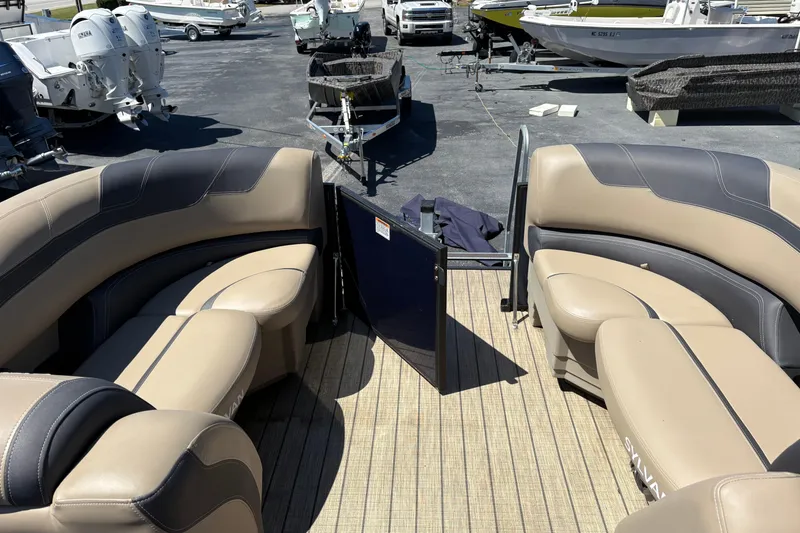 Slide: The Image of 2024 Sylvan L3 CLZ pontoon boat interior with beige seating and open gate. - 4