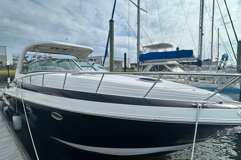 The Image of 2015 Crownline 350 SY yacht docked at marina under cloudy sky. - 1