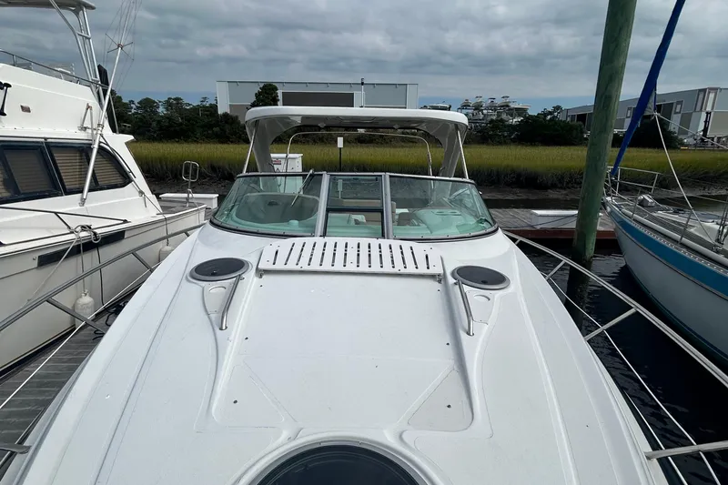 Slide: The Image of 2015 Crownline 350 SY boat docked, showcasing sleek design and spacious deck. - 13