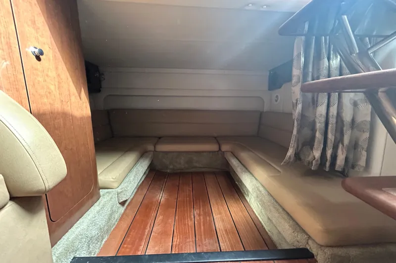 Slide: The Image of 2015 Crownline 350 SY cabin interior with wooden flooring and beige seating. - 15